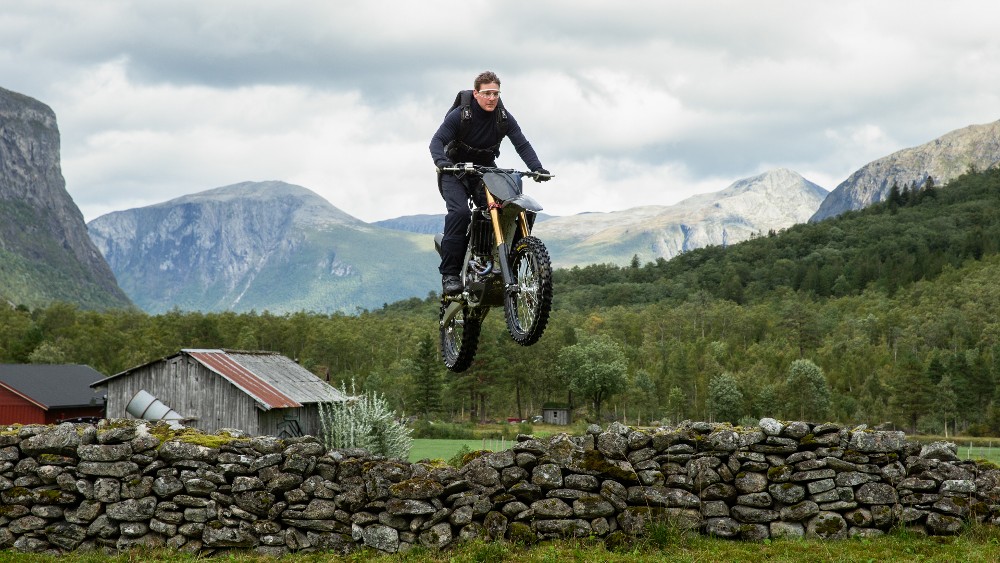 Tom Cruise performing the death-defying motorcycle cliff jump — one of the most iconic stunts in action movie history. No CGI. No stunt double.